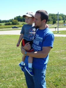 Elias and Daddy watching Greg approach the helipad