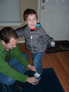 Elias was excited to go to preschool. Here he is excited while Daddy is trying to help him with his shoes. (His hair is wet because I had tried to comb it)