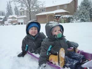 The boys happy while being pulled on the sled.